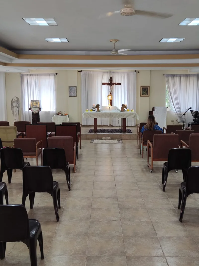 Vista del interior de la capilla desde los bancos hacia el altar