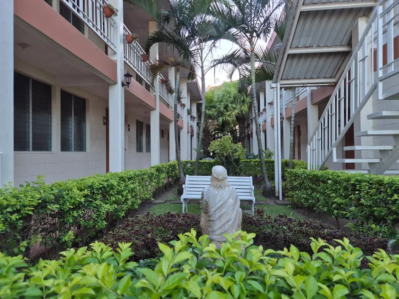 Sendero y bancos entre los jardines y los edificios de la casa