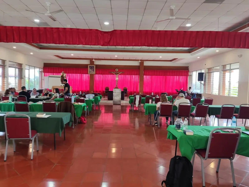 Salón de conferencias con mesas y sillas dispuestas para una actividad